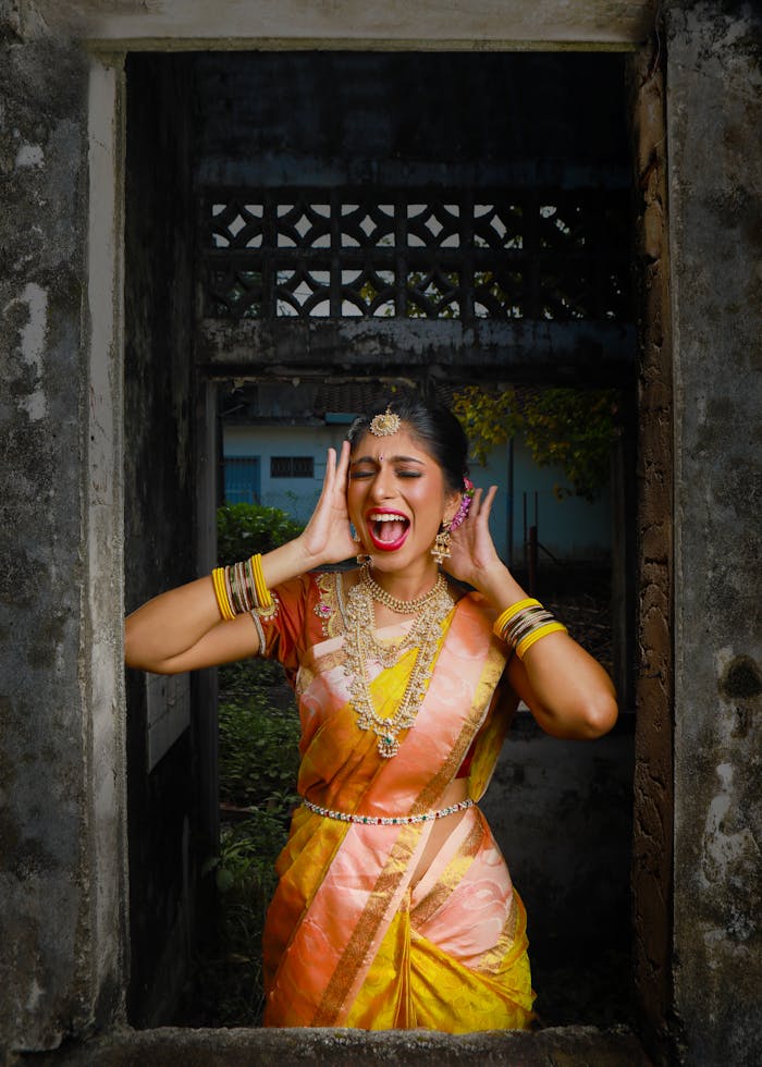 A vibrant woman in a traditional Indian saree expressing joy vividly through her facial expression.